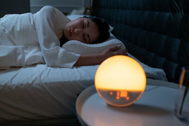 kobieta śpi przy zapalonej lampce